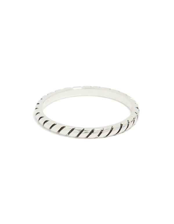 Highlighting a textured sterling silver statement ring with black enamel detailing close up view
