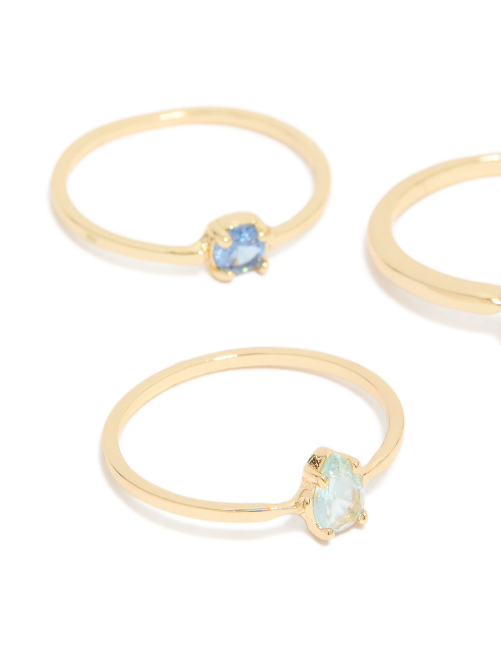 Showcasing gold plated blue cubic zirconia and bubble rings in a stackable 5-pack with oval, round, and heart stone details, close up view