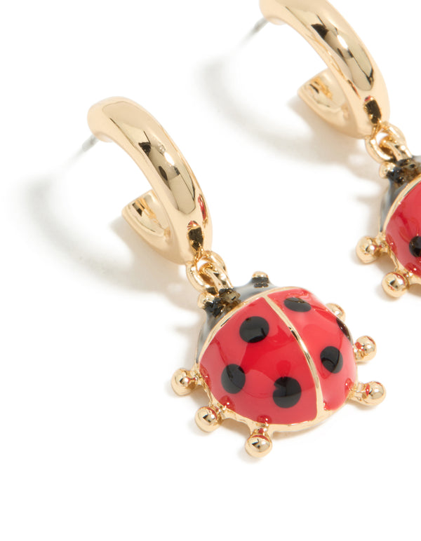 Explore gold ladybug huggie earrings in red and black close up view
