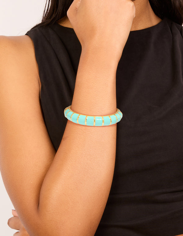 Featuring this waterproof ribbed blue enamel bangle crafted from stainless steel with gold plating on wrist view