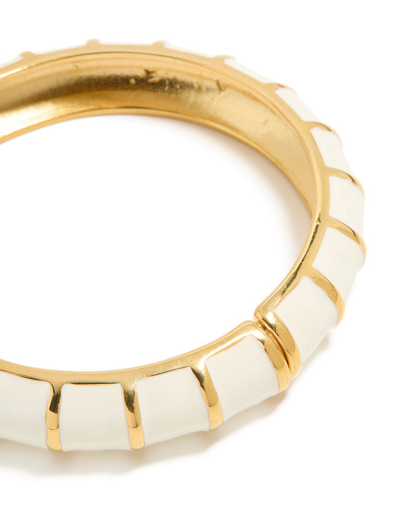 Close up view of waterproof ribbed bangle in gold plated stainless steel with white enamel close up view