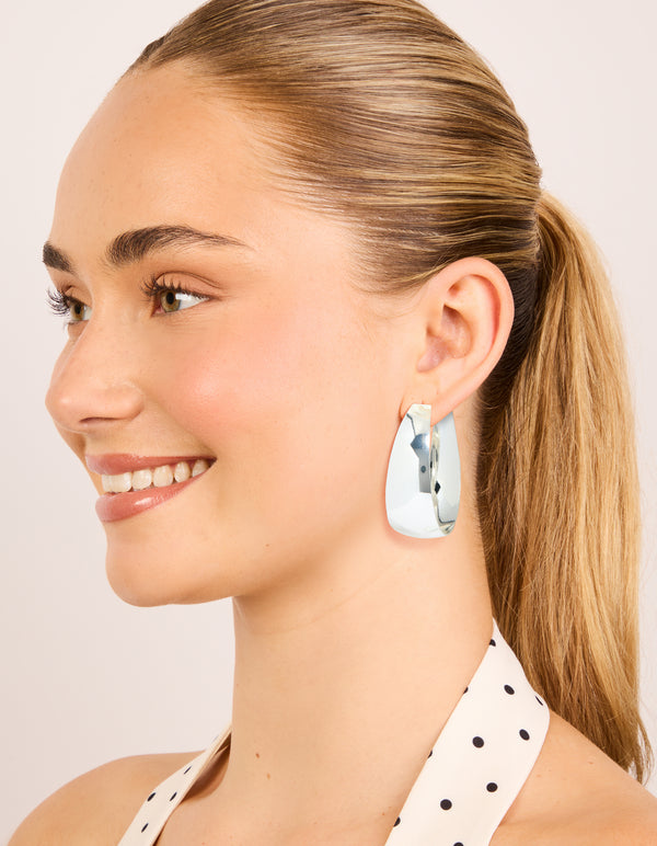 Highlighting silver plated smooth thick hoop earrings with closure on model view