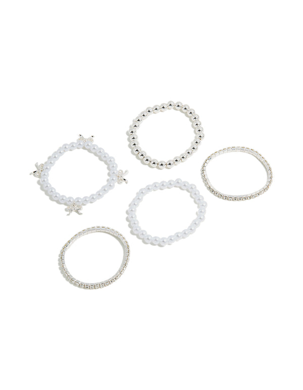 Showcase five kids stretch bracelets featuring beaded designs with bow charms and pearl accents in silver and white front view