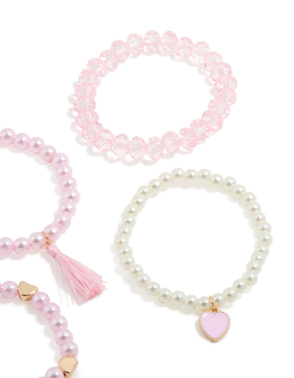 Showcasing kids beaded pearl and heart stretch bracelets in a 5-pack featuring tassel details in gold, light pink, ivory, and salmon hues close up view