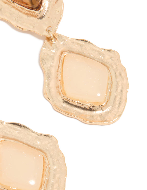 Highlighting intricate craftsmanship, these gold molten Aztec drop earrings display statement design post detail view