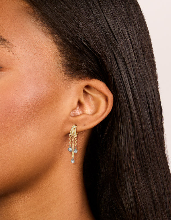 Showcasing mixed metal plated cubic zirconia illusion hoop chain drop earrings with charm in statement style featuring gold, silver and clear stone on ear view