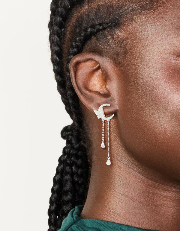 Elegant silver plated cubic zirconia moon and butterfly drop earrings with celestial charm pearl accents on ear view