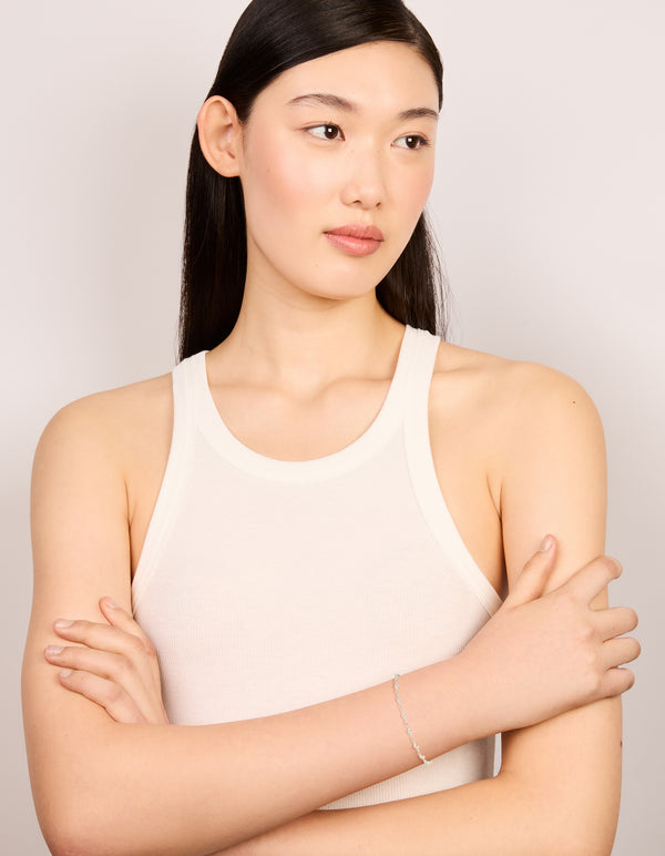 Crafted from silver plated material is this cubic zirconia round dainty chain bracelet on model view