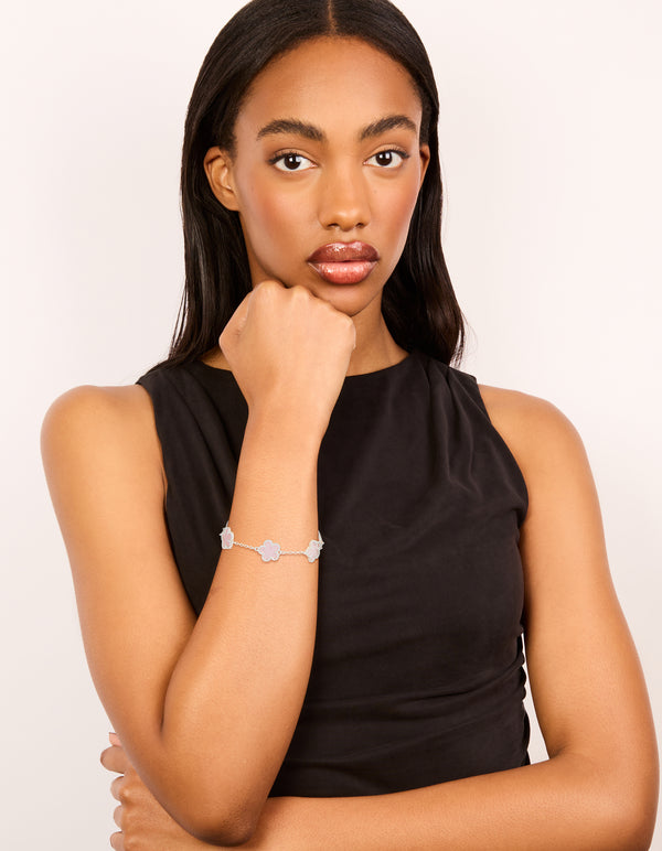 Crafted from silver plated material, this pink flower charms station bracelet features floral pattern in dainty style on model view