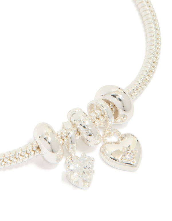 Featuring silver plated finish, this dainty bow and heart charm bracelet has cubic zirconia accents in close up view