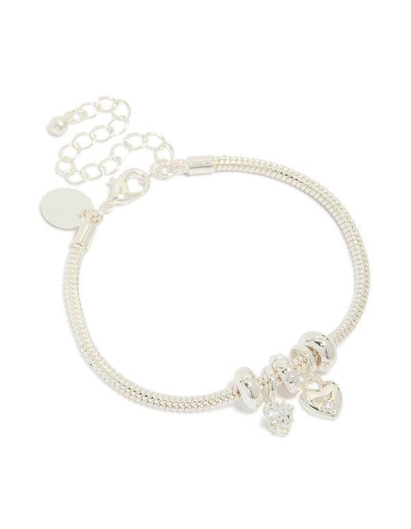 Showcasing a dainty silver plated charm bracelet featuring bow and heart details with cubic zirconia accents front view