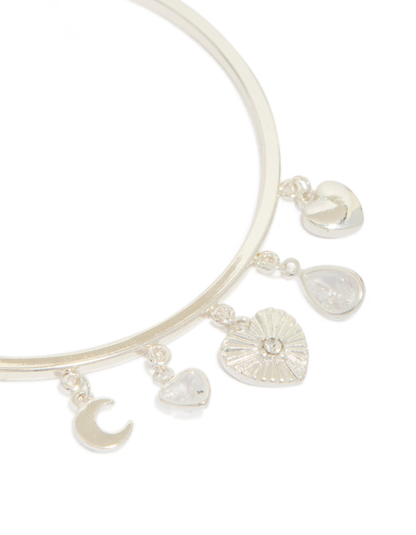 Designed with silver plated finish, this moon and heart charm toggle bangle features celestial elements close up view