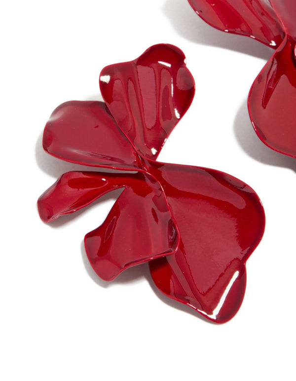 Featuring large statement stud earrings with floral petal design in red coated metal close up view