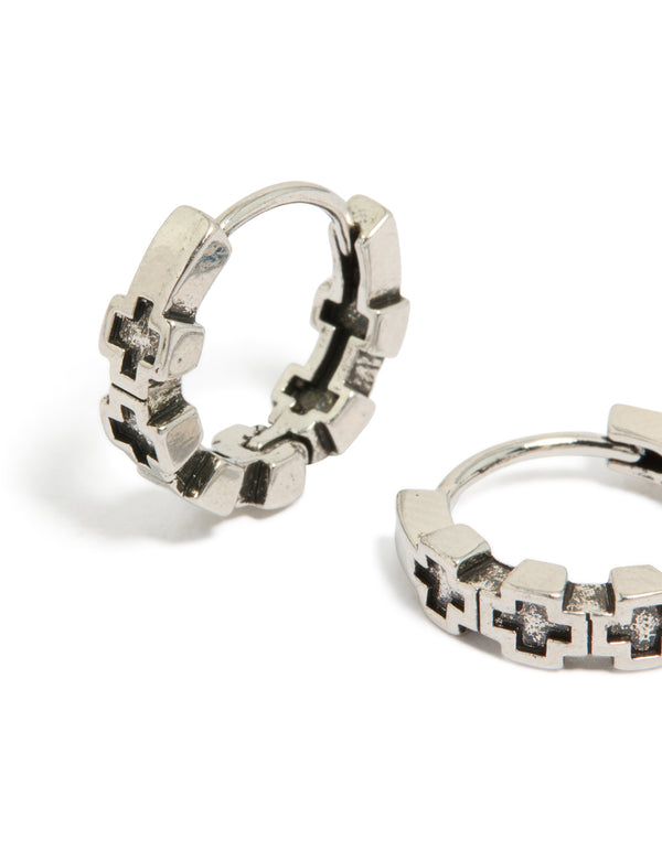 Crafted from waterproof brushed stainless steel with multiple cross details, these mens huggie hoop earrings in silver and black close up view