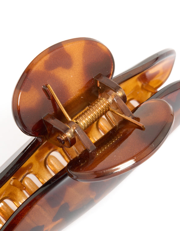 Featuring an arched tortoiseshell claw clip in chocolate sienna and peru shades detail view