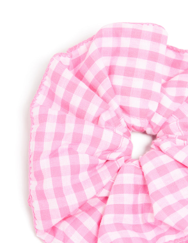 Featuring checkered fabric, this ruffled scrunchie in pink and white detail view