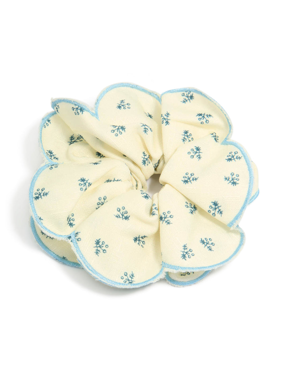 Showcasing a ruffled scrunchie with floral print in ivory, sky blue and teal front view