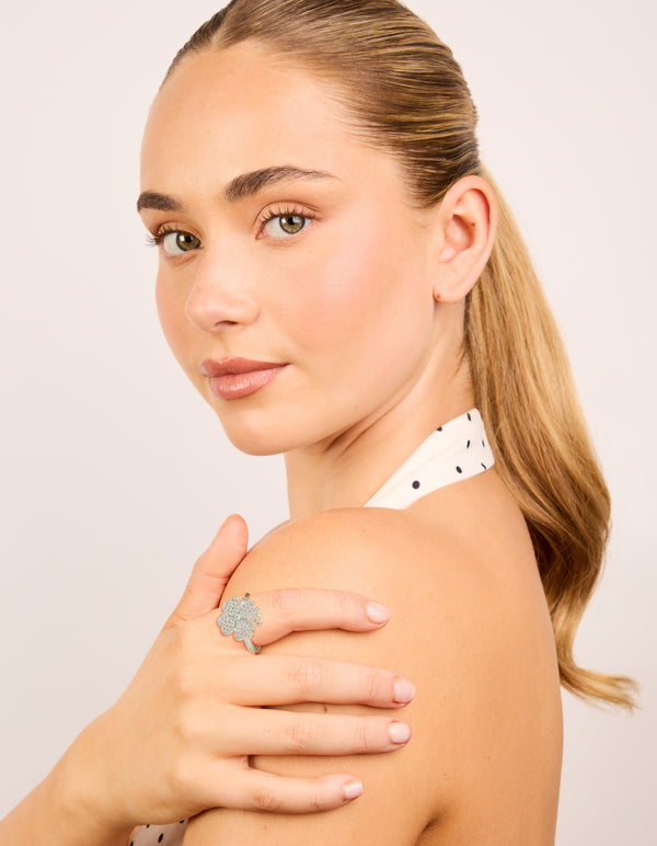 Crafted from waterproof stainless steel, this spinning clover ring features floral with cubic zirconia in silver and clear on finger view