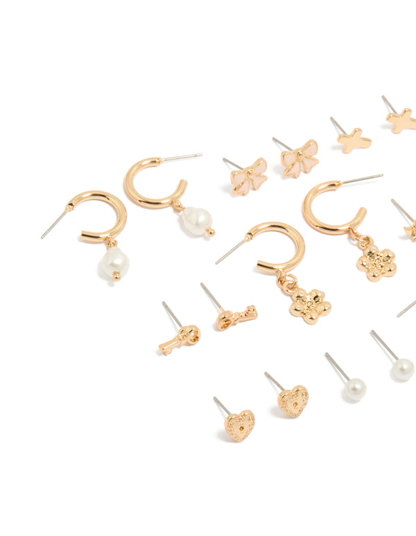 Explore this dainty stud earrings 12-pack featuring bow charm cross floral, balls and heart designs enamel crafted in gold with pearl accents white and pink details close up view