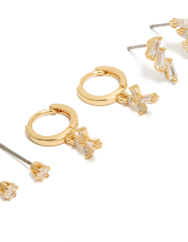 Highlighting dainty charm and cross huggie with trio baguette studs crafted from gold plated cubic zirconia in a 3-pack close up view