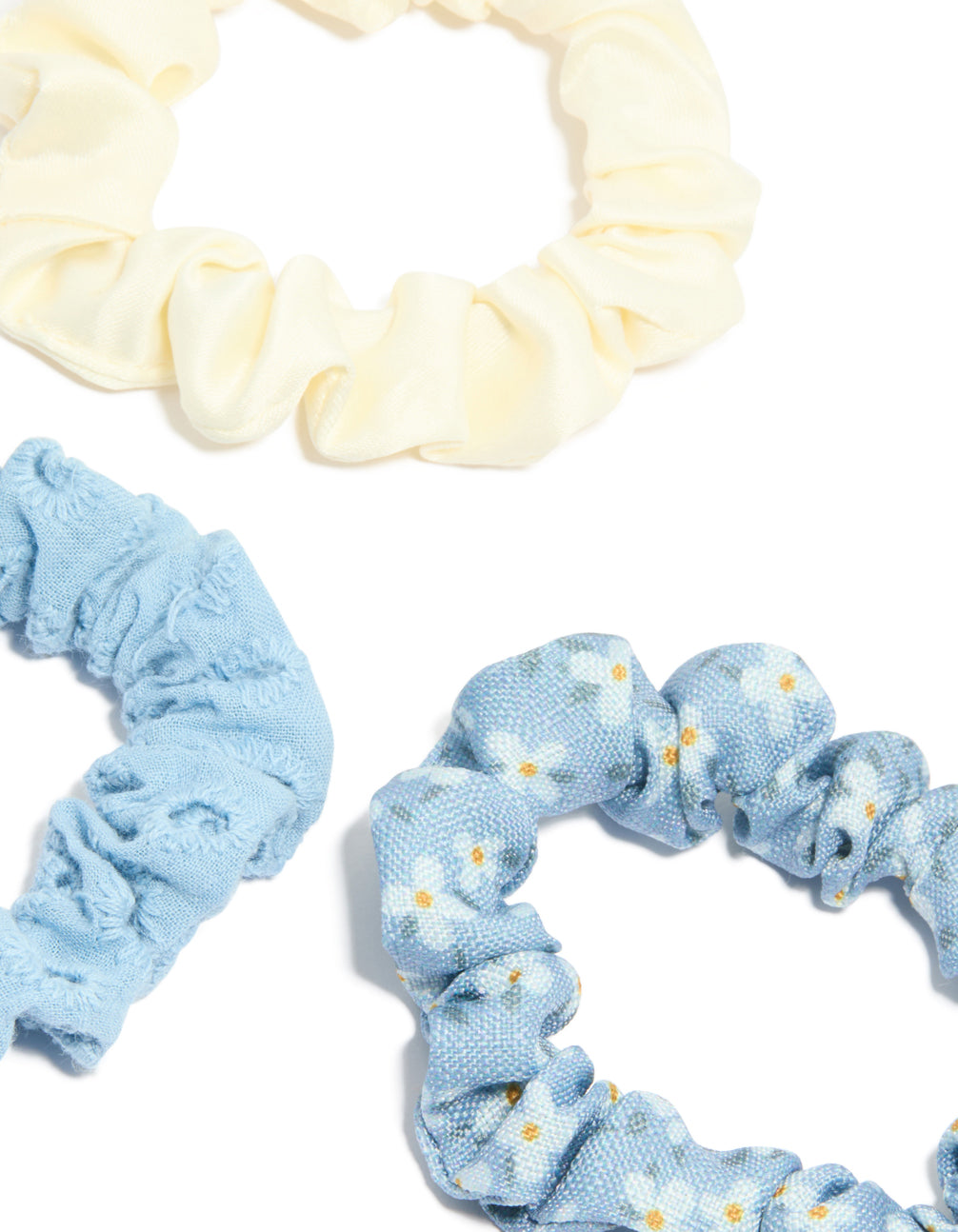 Crafted from daisy flower and checkered fabric scrunchies in a 5-pack with light blue, ivory, white side view