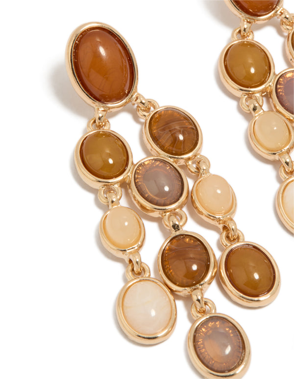 Featuring gold brown stones oval drop earrings close up view