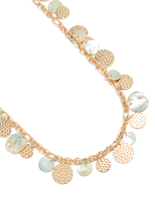 Showcasing a statement necklace with charm ocean elements featuring shell in gold close up view