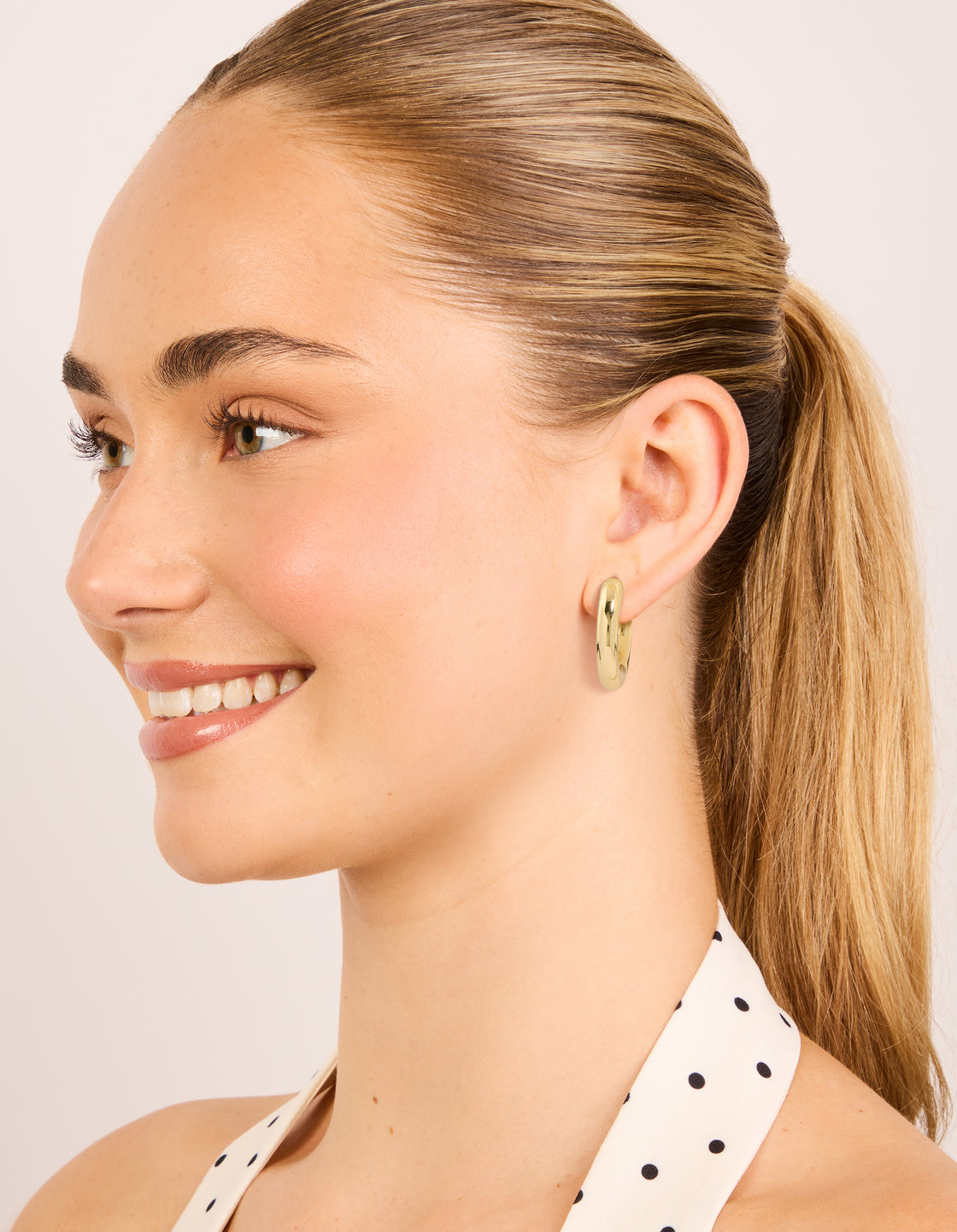Presenting gold plated plain thin huggie earrings 2-pack with hoop closure on model view