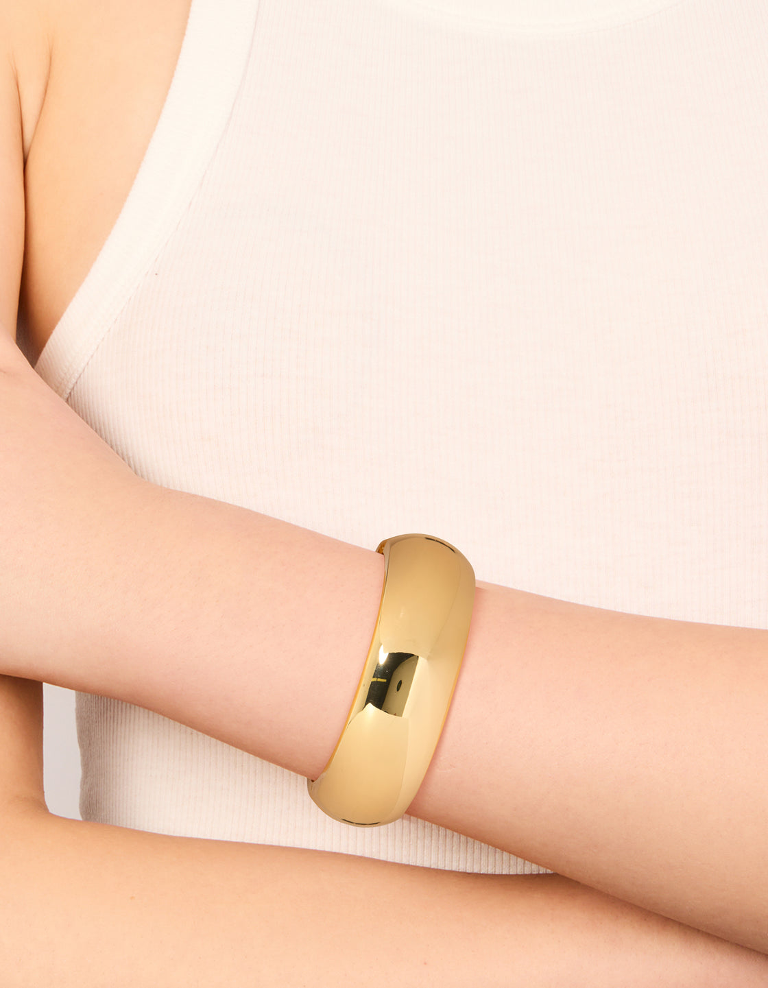 Featuring a gold plated circle statement bangle on wrist view