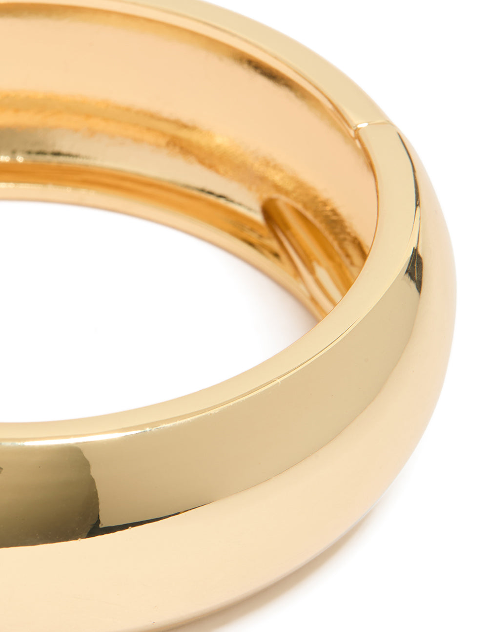 Highlighting a gold plated circle statement bangle close up view