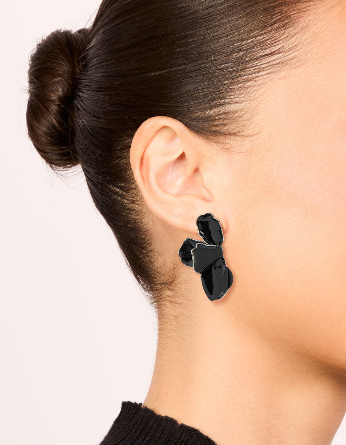Elegant chunky mini petal drop earrings in black coated metal and silver accents on ear view