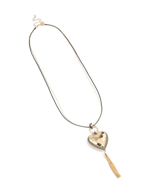 Discover a mixed metal chunky heart tassel cord layered necklace with charm accents in silver and gold front view