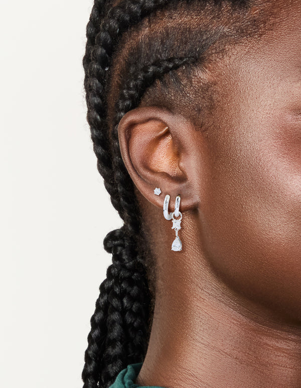 Showcasing stainless steel cubic zirconia mixed drop hoop earrings 3-pack featuring crystal waterproof material with stud closure in silver and clear on ear view