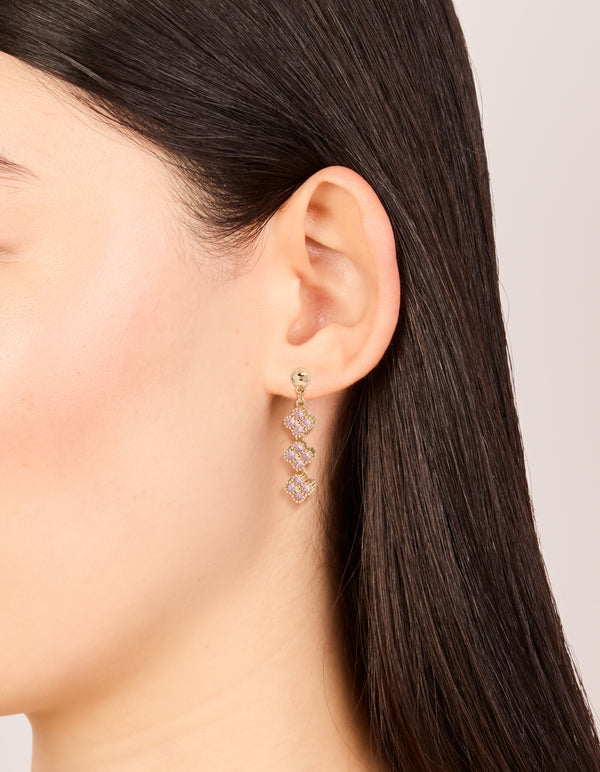 Elegant gold pink cubic zirconia flower trio drop earrings on ear view