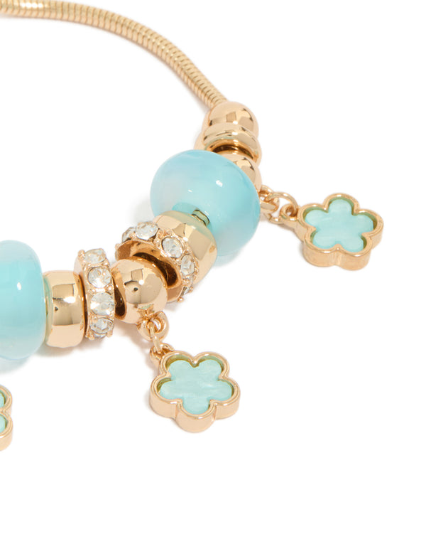 Crafted with beaded charm bracelet and floral accents in gold and light blue close up view