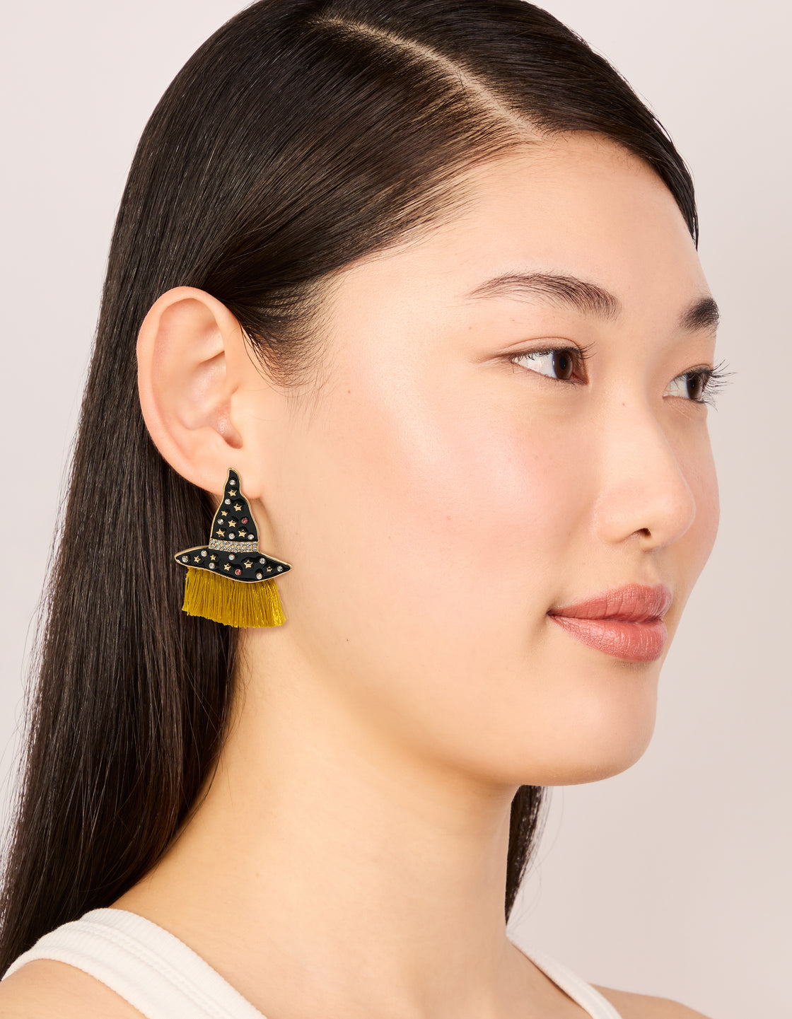 Elegant gold witch hat drop earrings showcasing celestial star and tassel elements on model view