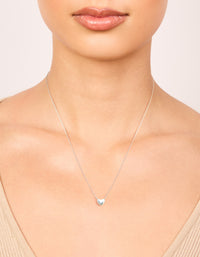 Showcasing a sterling silver mini puffy heart charm pendant necklace with dainty styling on neck view - link has visual effect only