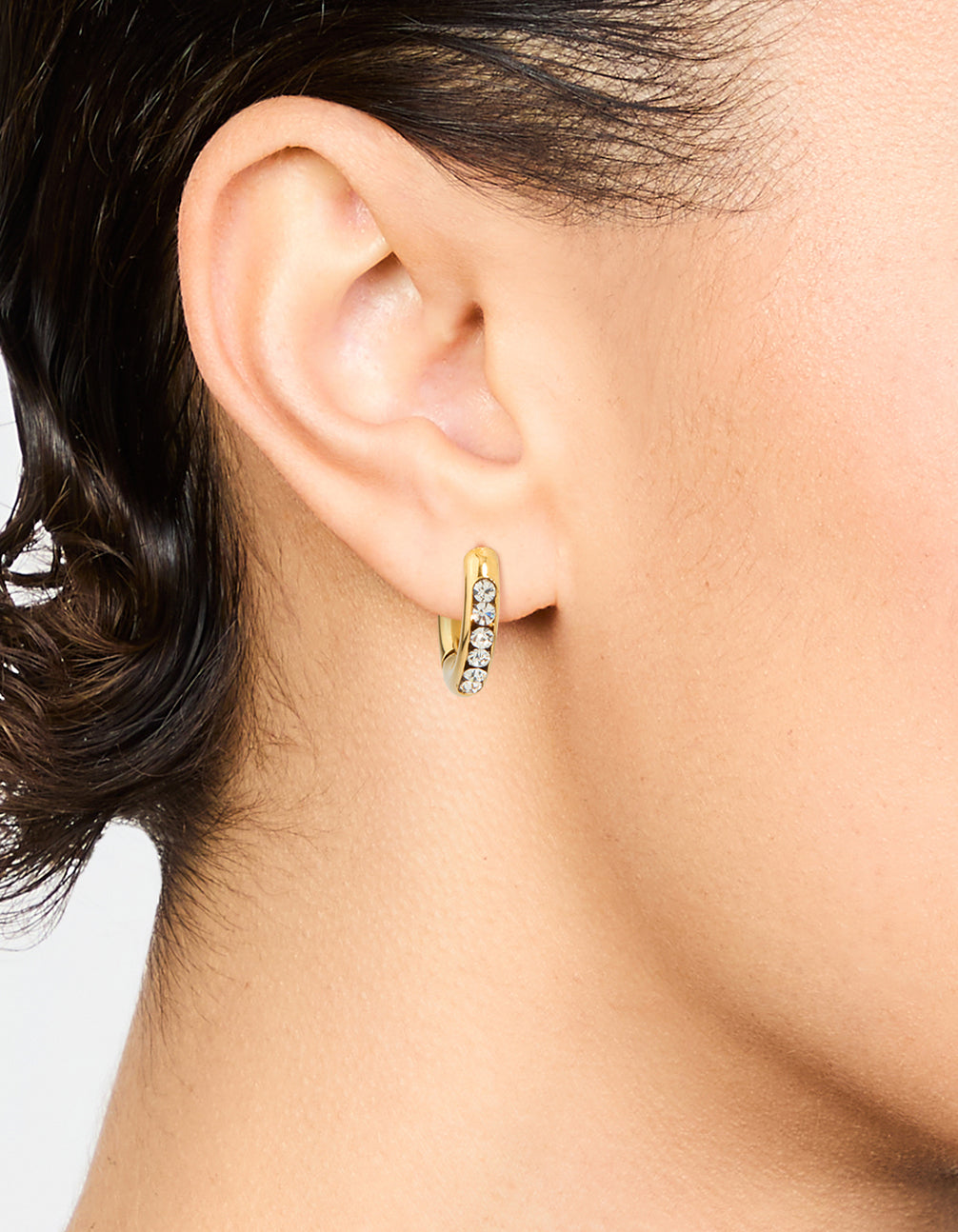 Featuring waterproof gold plated stainless steel round diamante clicker hoop earrings on ear view