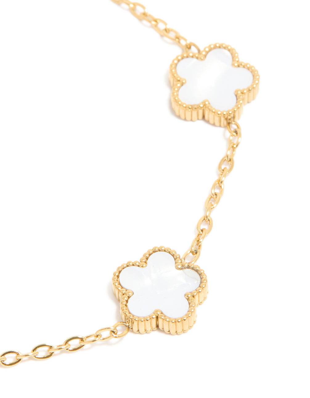 Highlighting a waterproof floral charm bracelet in gold plated stainless steel with white features close up view