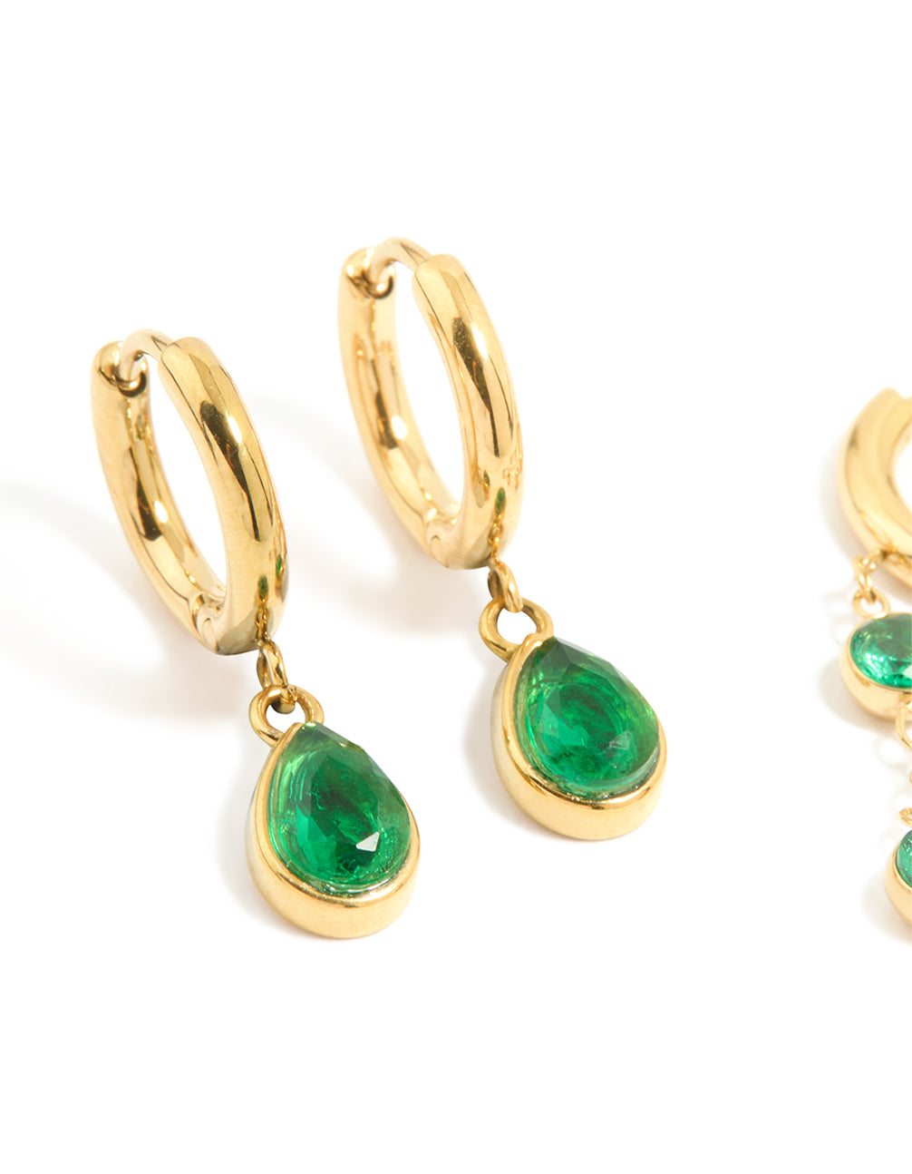 Featuring waterproof gold plated stainless steel green cubic zirconia huggie earrings in a 2-pack close up view