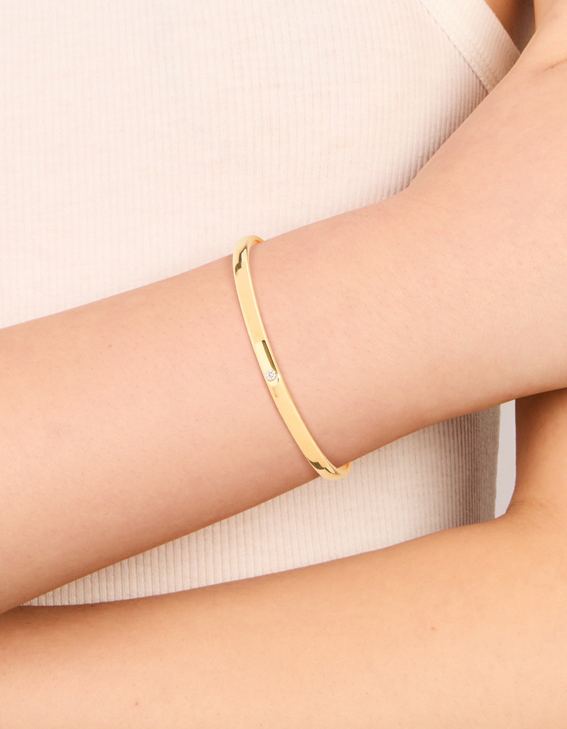 Showcasing a waterproof smooth open wrist cuff crafted from gold plated stainless steel with dainty style on wrist view