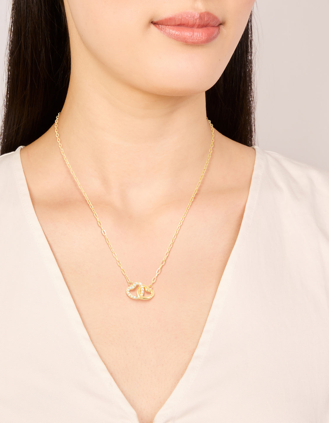 Beautifully designed waterproof gold plated stainless steel interlocking heart pendant necklace with charm on neck view