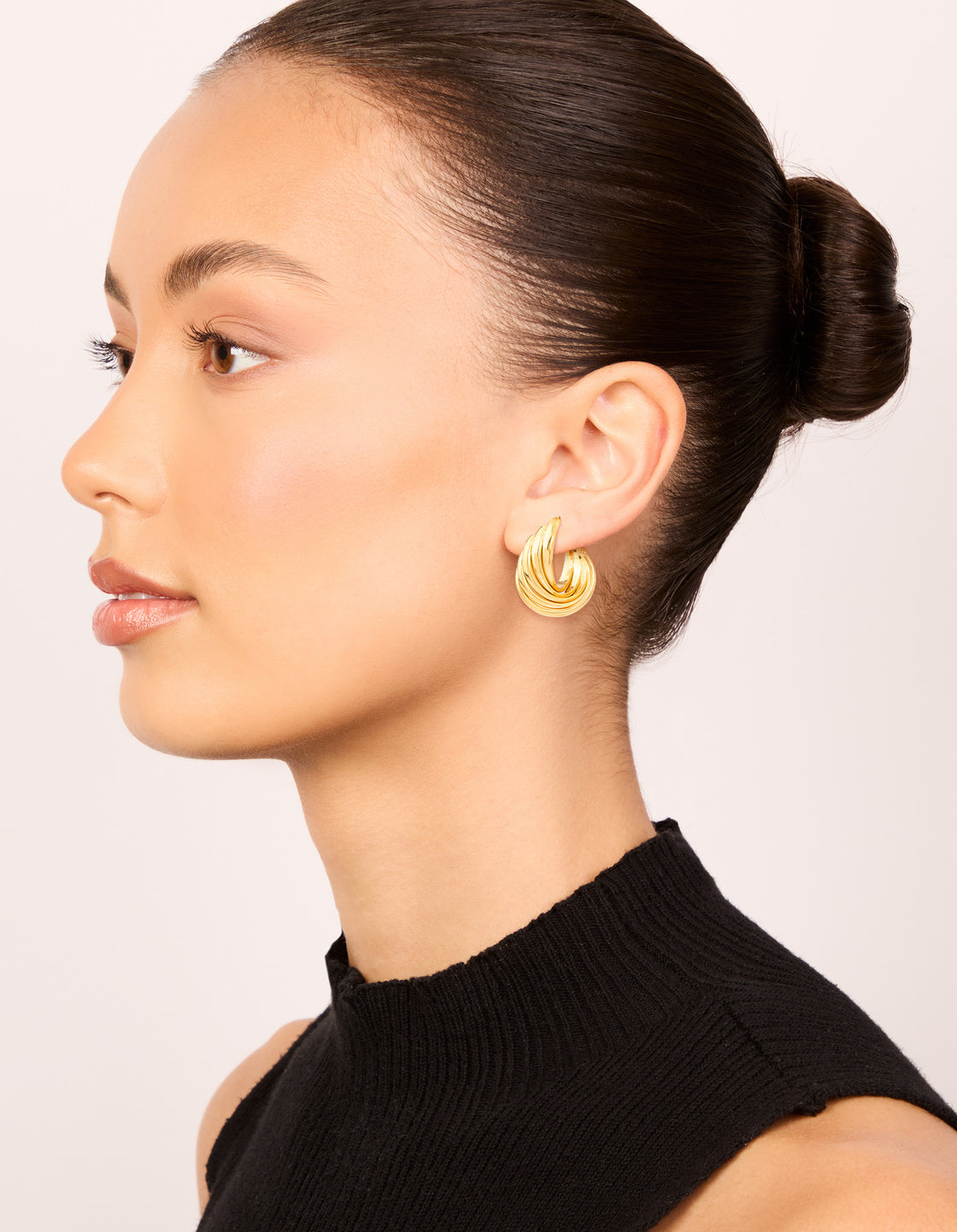 Waterproof gold plated stainless steel 4-row twisted hoop earrings in statement style on model view