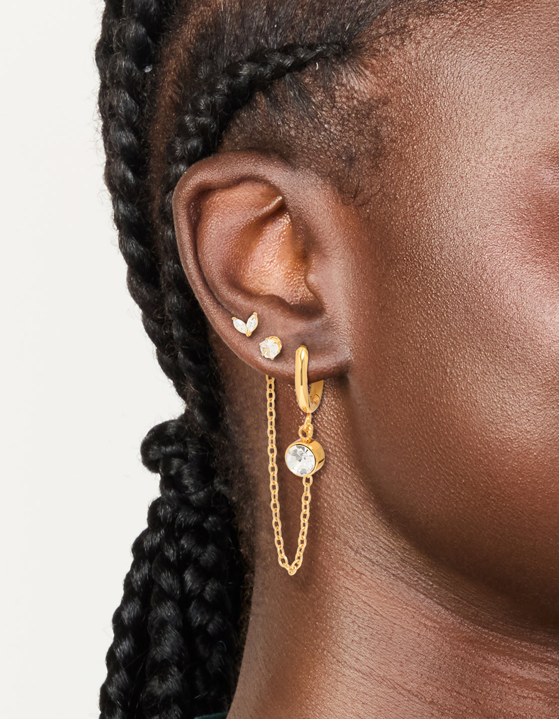 Showcasing waterproof gold plated stainless steel cubic zirconia mixed earrings with huggie and stud closure in a 2-pack on ear view