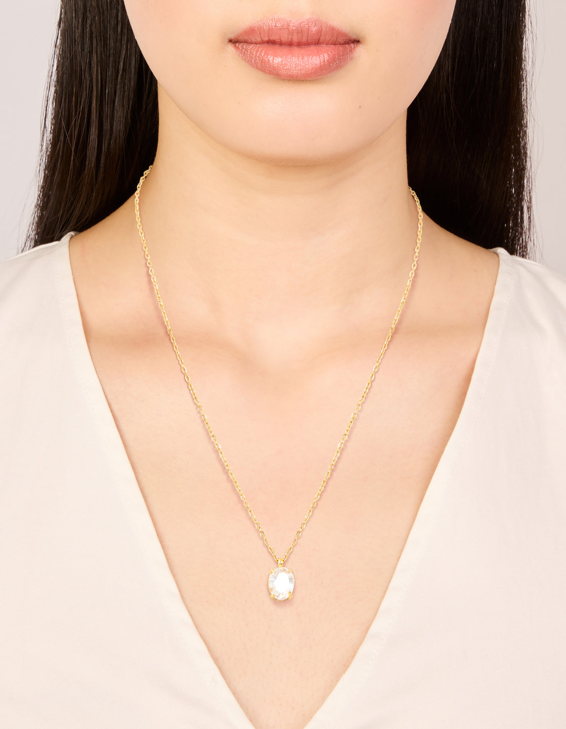 Showcasing a waterproof gold plated stainless steel oval cubic zirconia pendant necklace on neck view