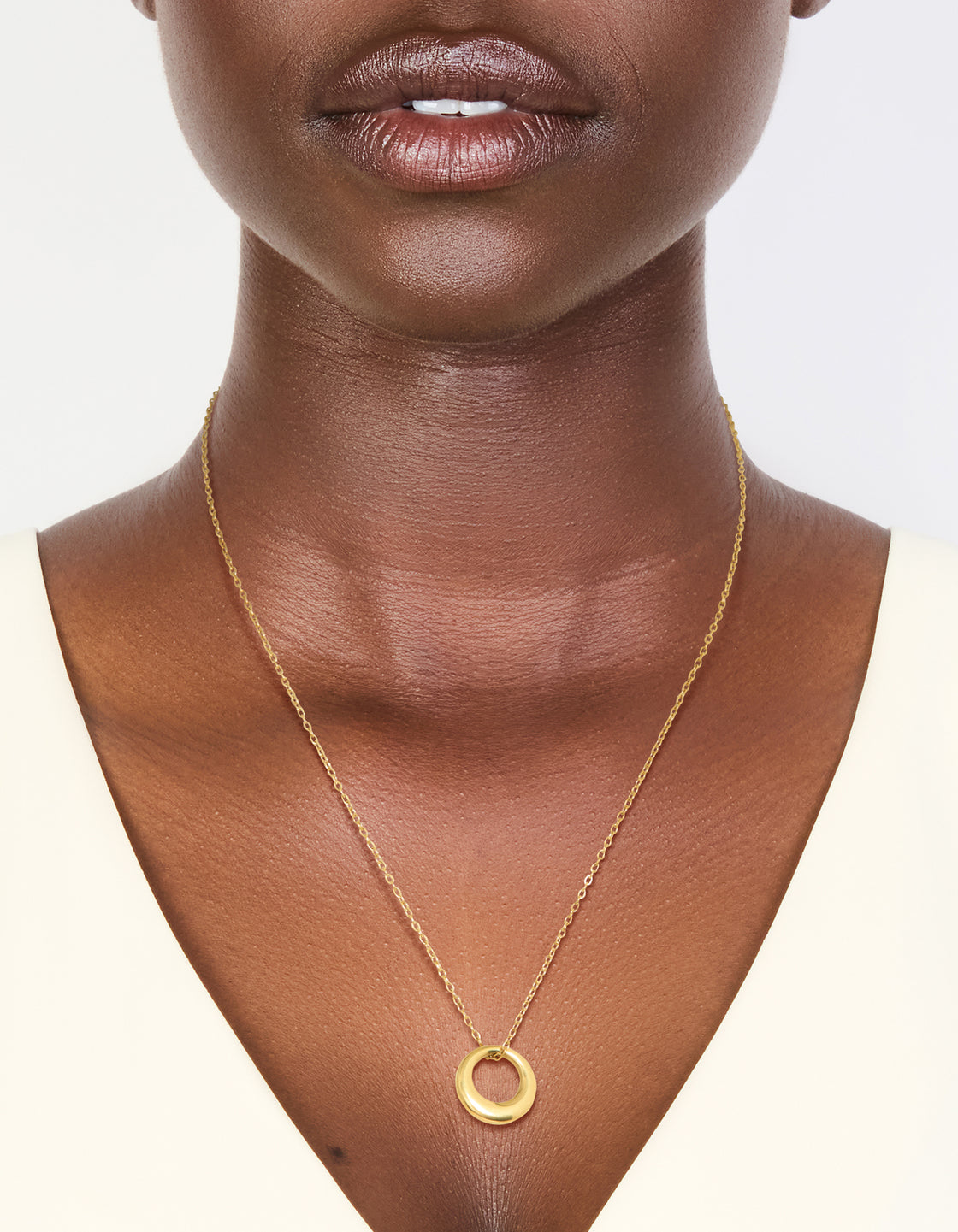 Showcasing a waterproof disc pendant necklace crafted from gold plated stainless steel on neck view