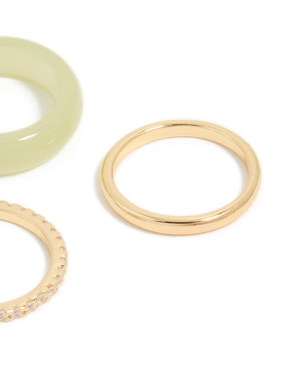 Showcasing gold plated acrylic and cubic zirconia rings in a statement 3-pack close up view