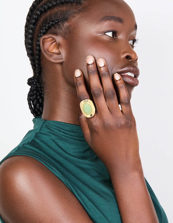 Elegant gold plated ring with oval pale green semi precious stone on finger view