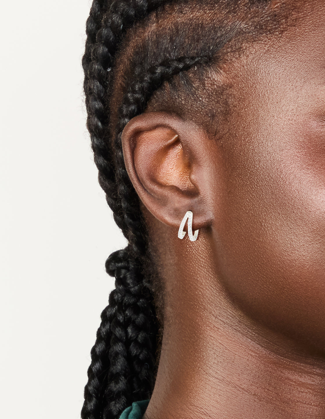 Showcasing dainty silver plated cubic zirconia double layered small earrings with huggie closure on ear view