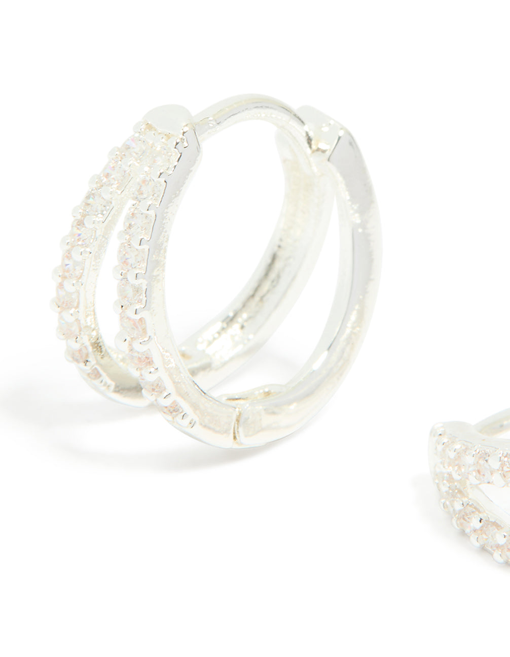 Highlighting dainty silver plated cubic zirconia double layered small earrings with huggie closure close up view
